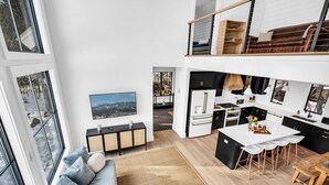 A modern loft apartment with a kitchen, dining area, and living space. - Unmatched Views of Sunday River! Slps 16! Hot Tub! (Newry)