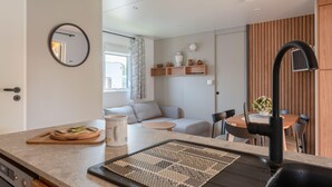 Une cuisine moderne avec un miroir rond, une planche à découper en bois et une tasse à café.