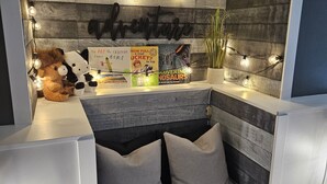 A cozy reading nook with a bench, books, and string lights.