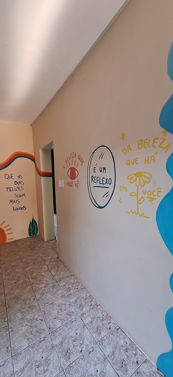 A hallway with motivational wall art and a tiled floor. - Meraki (Paranaguá)