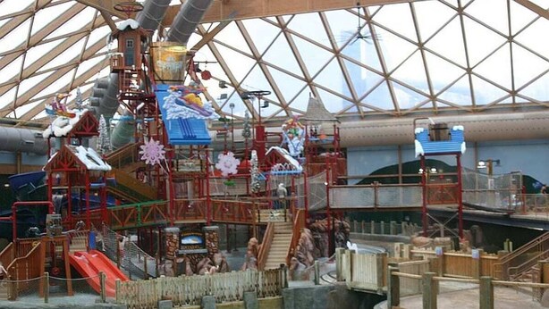 An indoor water park with multiple slides, a large glass dome structure, and various play areas. - Stunning Views and Tastefully Decorated; Middle of Mtn; Work Space; Games & WiFi (McGaheysville)