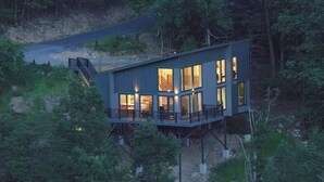 A modern cabin with a deck, surrounded by trees. - Stunning Views and Tastefully Decorated; Middle of Mtn; Work Space; Games & WiFi (McGaheysville)
