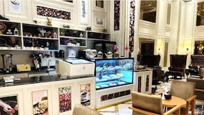 A boutique hotel lobby with a coffee bar, seating area, and a large digital display. - Verta Hotel Qouraish (Jeddah)