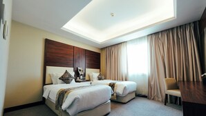 A hotel room with two beds, a desk, and a chair. - Verta Hotel Qouraish (Jeddah)