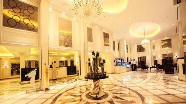 A spacious lobby with a central column, a reception desk, and a chandelier. - Verta Hotel Qouraish (Jeddah)