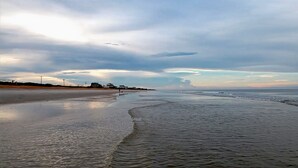 Une plage dotée d’un large rivage sablonneux et de vagues douces.