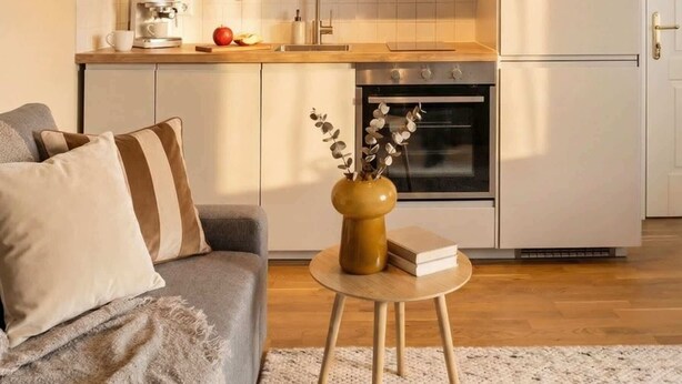 A modern kitchen with dark cabinets, a white countertop, and a built-in oven. - TurnKey | Angelo Roma Studio – Cozy Balcony (Praha 2)
