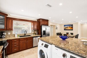 A modern kitchen with granite countertops, stainless steel appliances, and wooden cabinets.