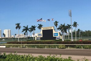 Un letrero de Gulfstream Park con banderas, el logotipo de Pepsi y un anuncio de un almuerzo especial del domingo.