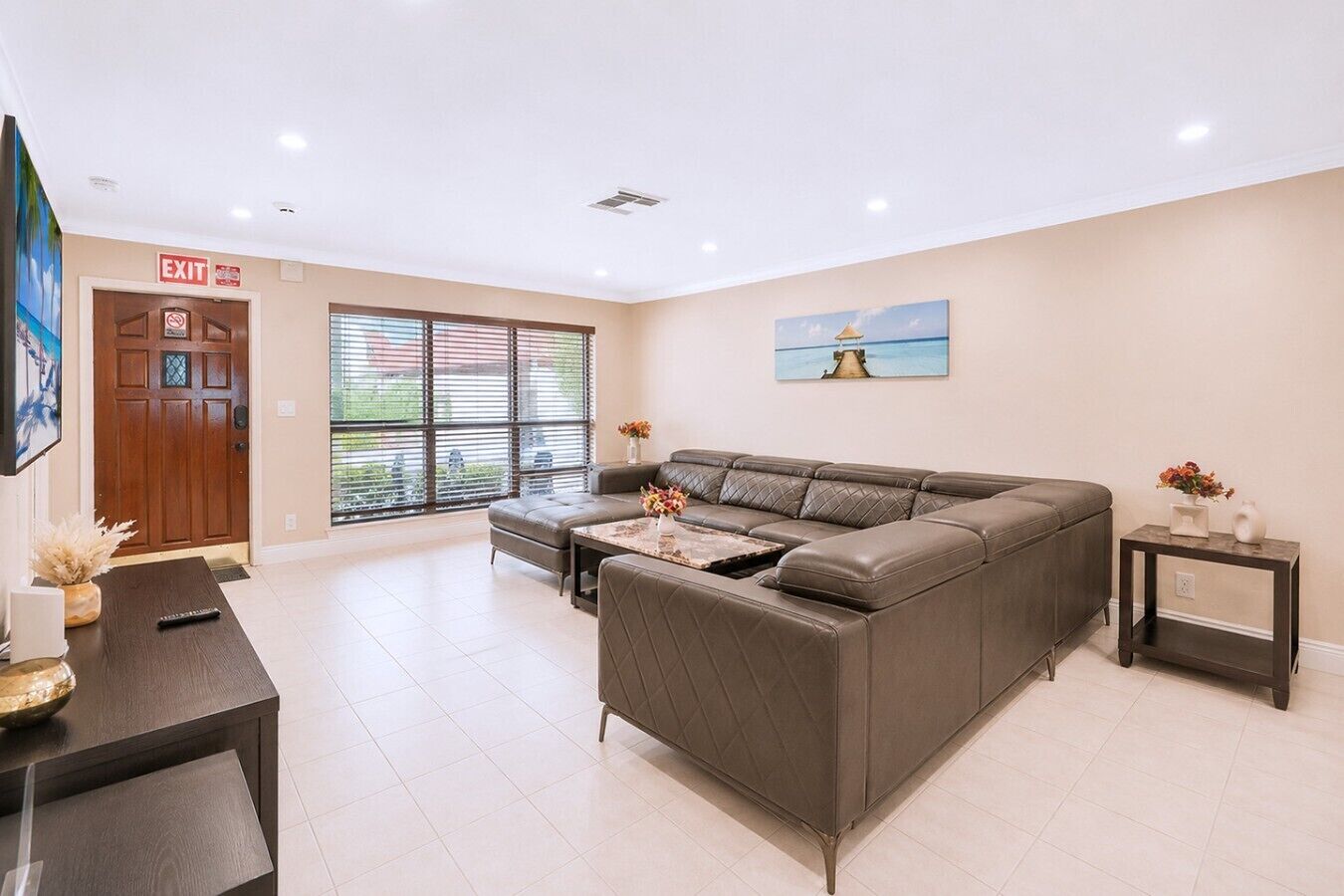 Uma sala de estar moderna com um sofá modular, uma mesa de centro e um quadro na parede.