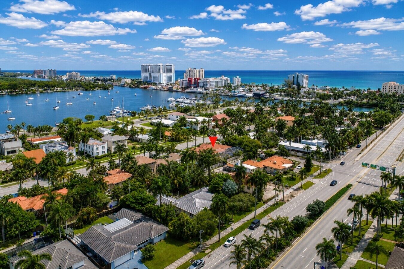 A coastal residential area with houses, a marina, and a clear blue sky.
