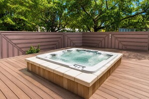 A hot tub on a wooden deck with a brown wall and trees in the background. - Amazing Villa Walk to Beach Heated Pool & Jacuzzi (Hollywood)
