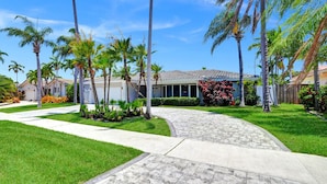 A residential area with a paved pathway, palm trees, and houses with tiled roofs. - Spectacular 5BR/5BA Villa in Hollywood Lakes (Hollywood)