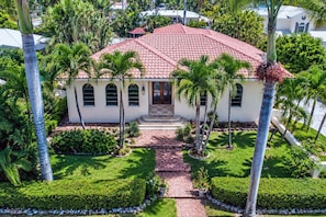 A house with a red-tiled roof, arched windows, and a front porch.