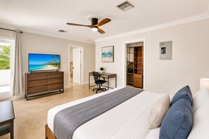 Een slaapkamer met een bed, bureau, televisie en kledingkast.