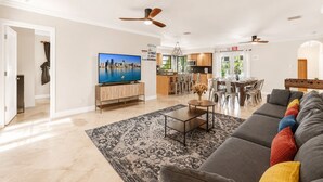 Una sala de estar moderna con un televisor de pantalla plana, un sofá, una mesa de centro y una alfombra estampada.