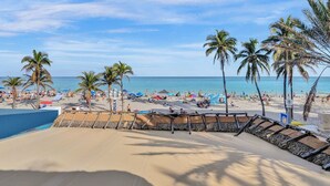 A beach with palm trees, a sandy area, and a clear blue sky. - Beach Condo - Hollywood Beachfront & Broadwalk (Hollywood)