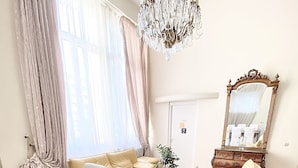 A spacious living room with a wooden herringbone floor, a large dining table set for six, a beige sofa, a cream-colored armchair, a wooden cabinet, and a large mirror. - Duplex in Cannes 5 min walk from the beach 5 BR (Cannes)