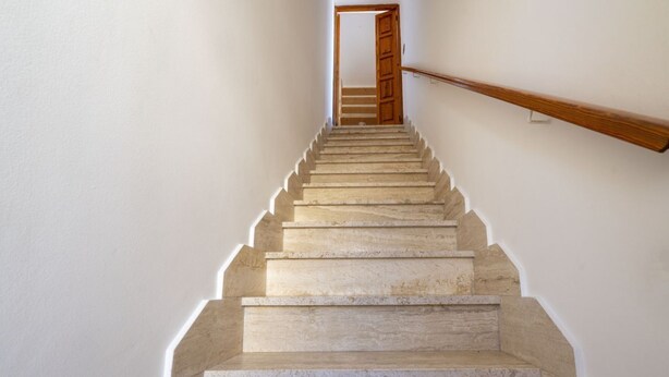 Una escalera de mármol que conduce a una puerta de madera en la parte superior.
