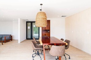 Enjoy meals in this dining area with a long table and six chairs, accompanied by a unique pendant light fixture.