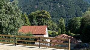 A view of a mountainous landscape with a red-roofed building in the foreground. - Monte Bar Old Cottage (Lugano)