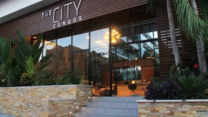 A modern building with a sign reading 'The City Condos.' - Premium Downtown PH +Private Pool +Gym+PKG+Rooftop (Playa del Carmen)