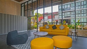 A modern indoor space with a sofa, two ottomans, a coffee table, and a patterned rug. - Premium Downtown PH +Private Pool +Gym+PKG+Rooftop (Playa del Carmen)
