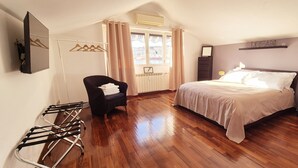 A bedroom with a bed, a chair, a radiator, a window with curtains, and a wall-mounted shelf. - Aroma Vaticano - Penthouse in residential area near the Vatican (60sqm-650sqft) (Roma)