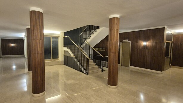 A spacious interior with a central staircase, polished floors, and wooden paneling on the walls. - Aroma Vaticano - Penthouse in residential area near the Vatican (60sqm-650sqft) (Roma)