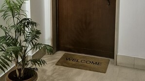 A brown door with a welcome mat and a potted plant beside it. - Aroma Vaticano - Penthouse in residential area near the Vatican (60sqm-650sqft) (Roma)