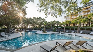 A pool area with lounge chairs and a building in the background. - Oceanfront Ocean Club Villa in Wild Dunes w/Hot Tub & Community Pool! *Unit 1212* (Isle Of Palms)