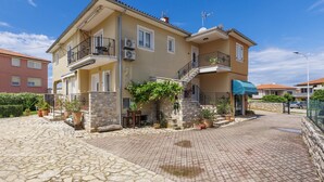 A two-story house with a stone facade, a balcony, and a blue awning. - Villa Ester by Interhome (Umag)