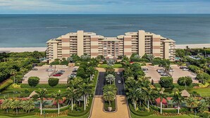 A high-rise hotel with multiple balconies, a parking lot, and a view of the beach. - Experience coastal comfort at The Somerset, your oceanfront haven on Marco Island (Marco Island)