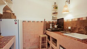 A compact kitchen with a refrigerator, stove, sink, and wicker baskets. - Riad Ghitaexclusif15 min de Jemaa El Fnaa (Marrakech)