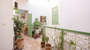 A narrow courtyard with green doors, potted plants, and a white railing. - Riad Ghitaexclusif15 min de Jemaa El Fnaa (Marrakech)