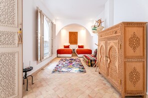 A bedroom with two beds, a colorful rug, a wooden cabinet, and a decorative wall panel. - Riad Mélina-Au Coeur de la Médina - Breakfast (Marrakech)
