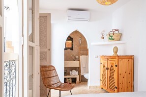 A bathroom with a shower, a wooden cabinet, and a wicker chair. - Riad Mélina-Au Coeur de la Médina - Breakfast (Marrakech)