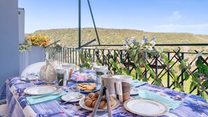 Mesa posta para refeição com vista para uma paisagem montanhosa.