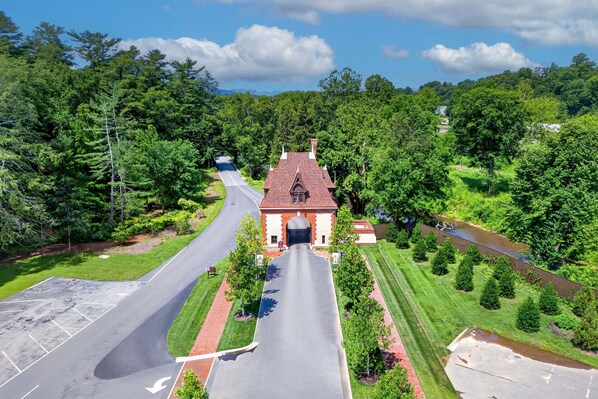 A building with a red roof, a driveway, and a road leading to it.
