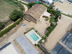 Vista aérea de una propiedad con piscina, terraza cubierta y zona de estacionamiento.
