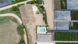 An aerial view of a property with a swimming pool, a large open area, and adjacent fields. - Villa 'Mas Tortós' with Mountain View, Private Garden and Barbecue (Palafolls)