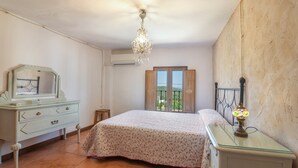 Une chambre à coucher avec un lit, une commode, un miroir et un lustre.