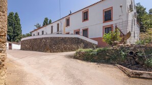 Un bâtiment doté d’un mur en pierre et d’une route pavée qui y mène.