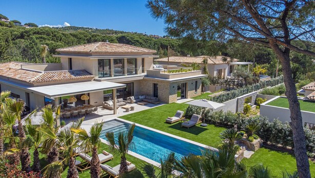 Une maison moderne dotée d’une piscine, d’un espace extérieur aménagé et d’un jardin bien entretenu.