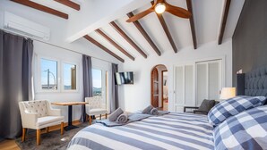 Ein Hotelzimmer mit Bett, Schreibtisch, Stuhl, Fernseher und einem Fenster mit Blick.
