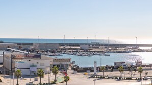 A marina with boats, a parking lot, and a building with a sign.