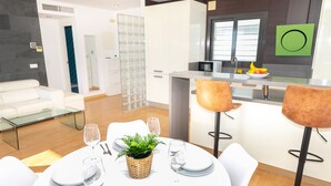 A modern living room with a dining area, a kitchen, and a bathroom.