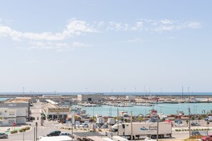 A marina with boats, a truck, and buildings along the waterfront. - Apartamento Vistas de Rajamanta | +Terraza, Playa + Garaje (Barbate)