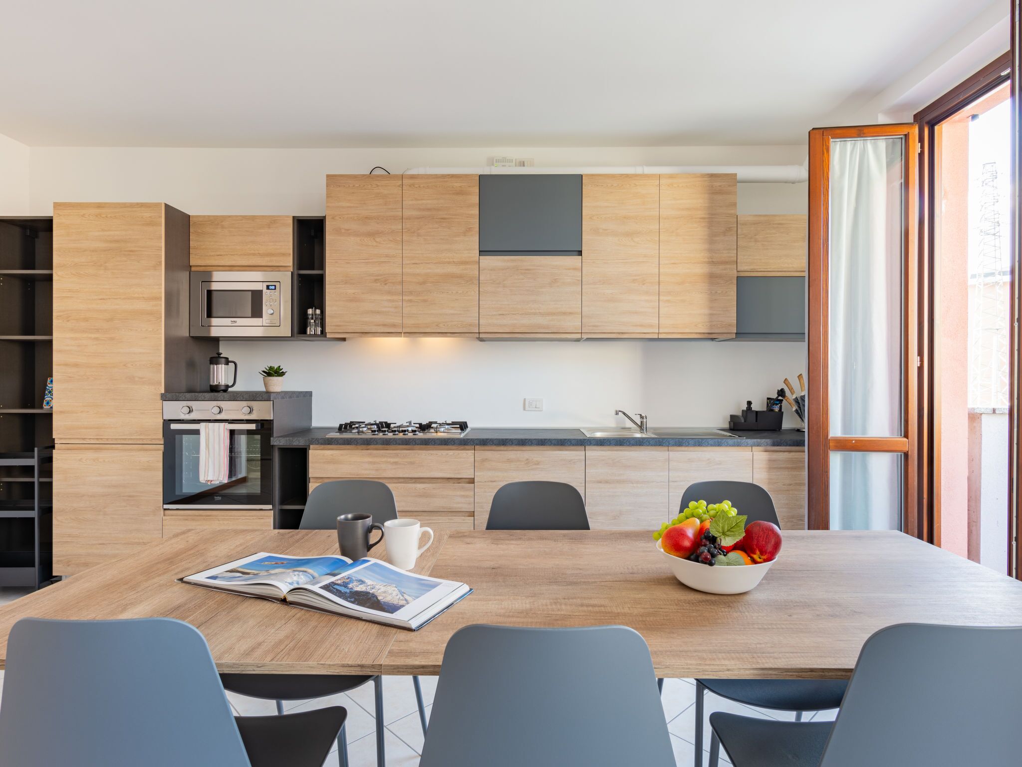 Une cuisine moderne avec des meubles en bois, un four encastré et une cuisinière à gaz.