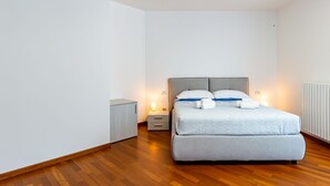 Une chambre à coucher avec un lit, des tables de chevet et un radiateur.